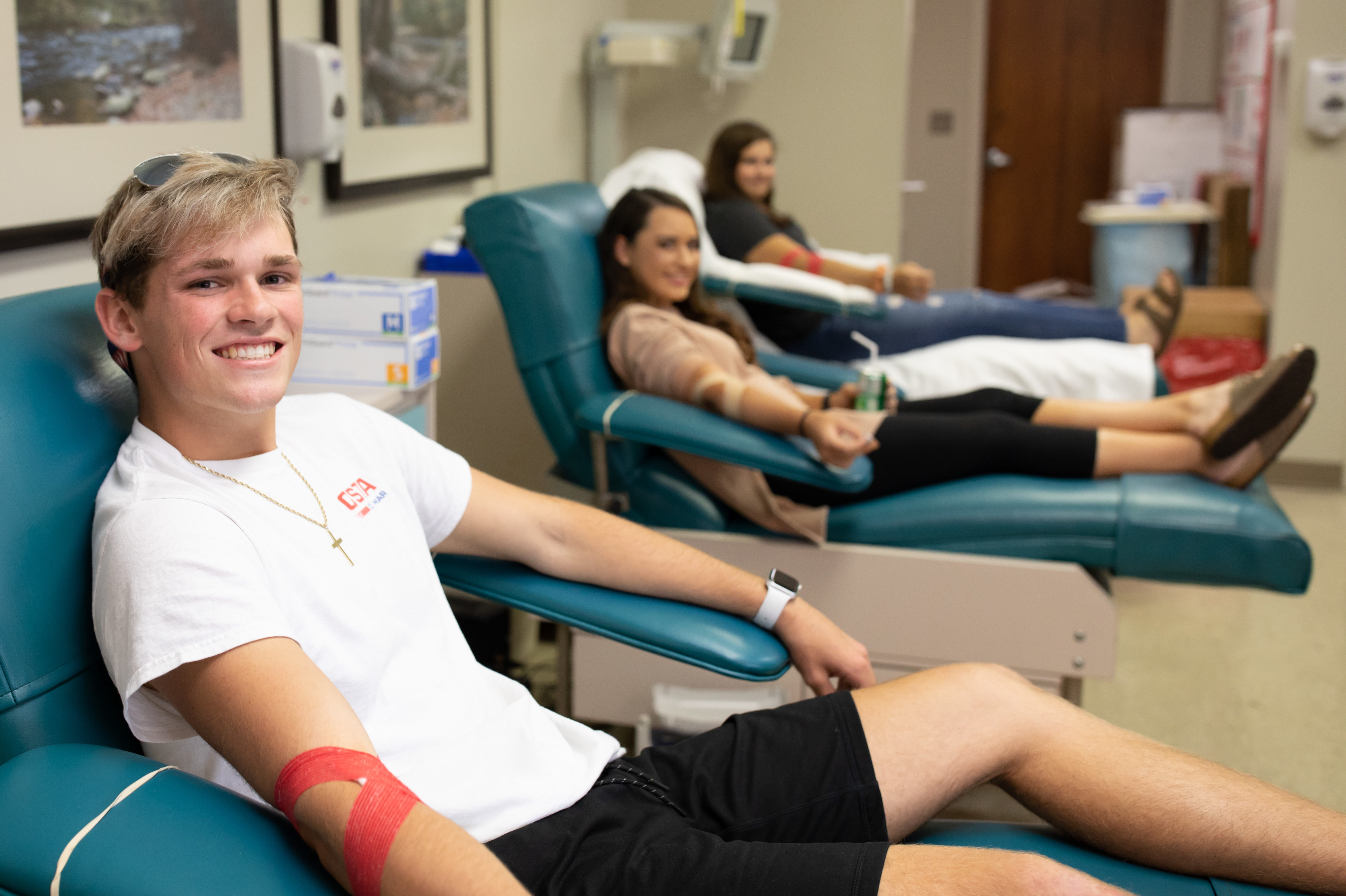 3 high school student donors in chairs after donating
