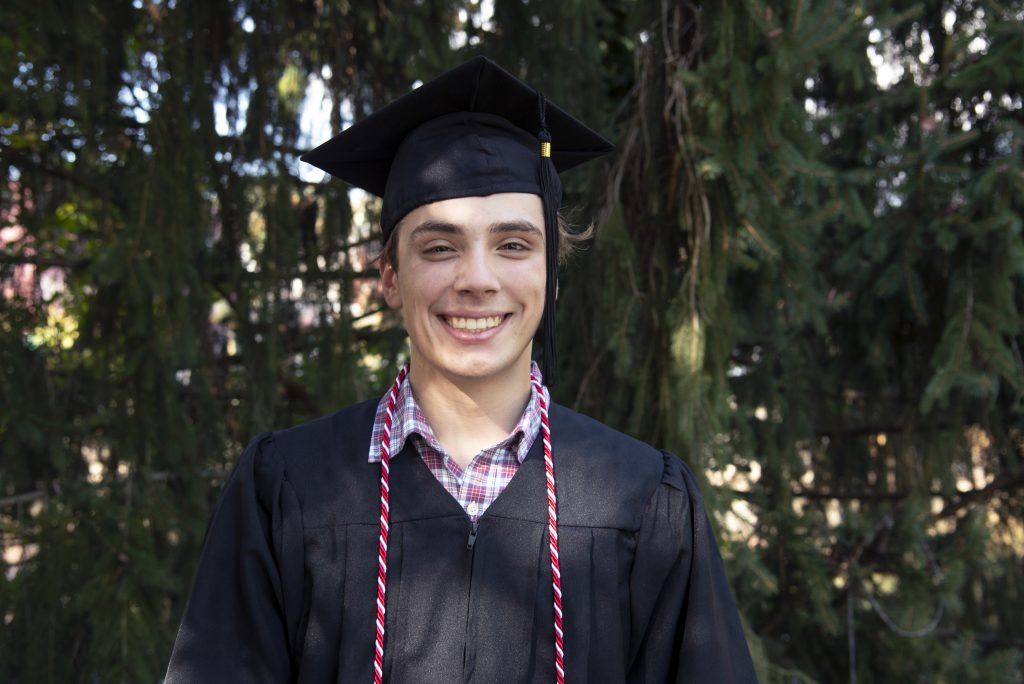 High school boy wears red and white cord to show he is a blood donor